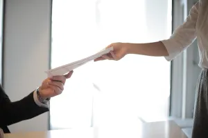 Employment Application Submission an image that reflects someone handing an employment manger applications for employment.