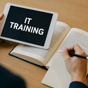 The image depects a text book with an ipad sitting on top of the open pages to reflect the IT training service that Infinigence LLC offers.